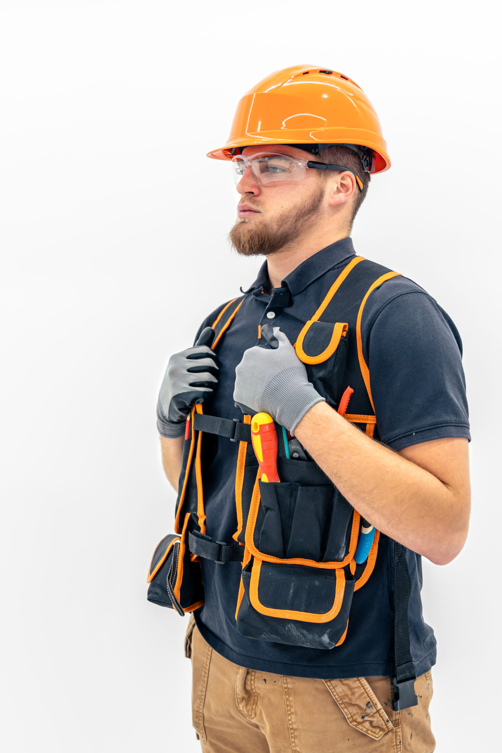 Male builder. Electrical engineer in overalls and helmet on light background. Construction concept.